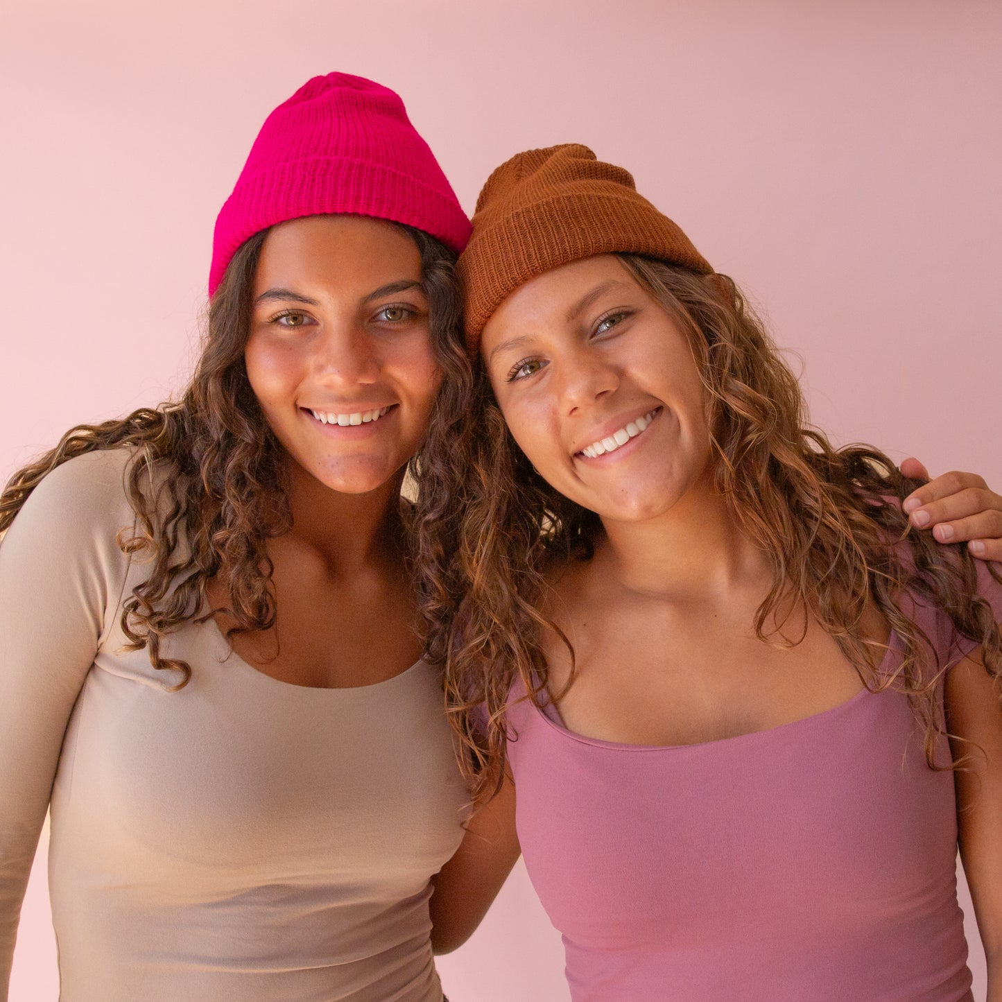 Models wearing the billie beanies in the shade Raspberry and chocolate.