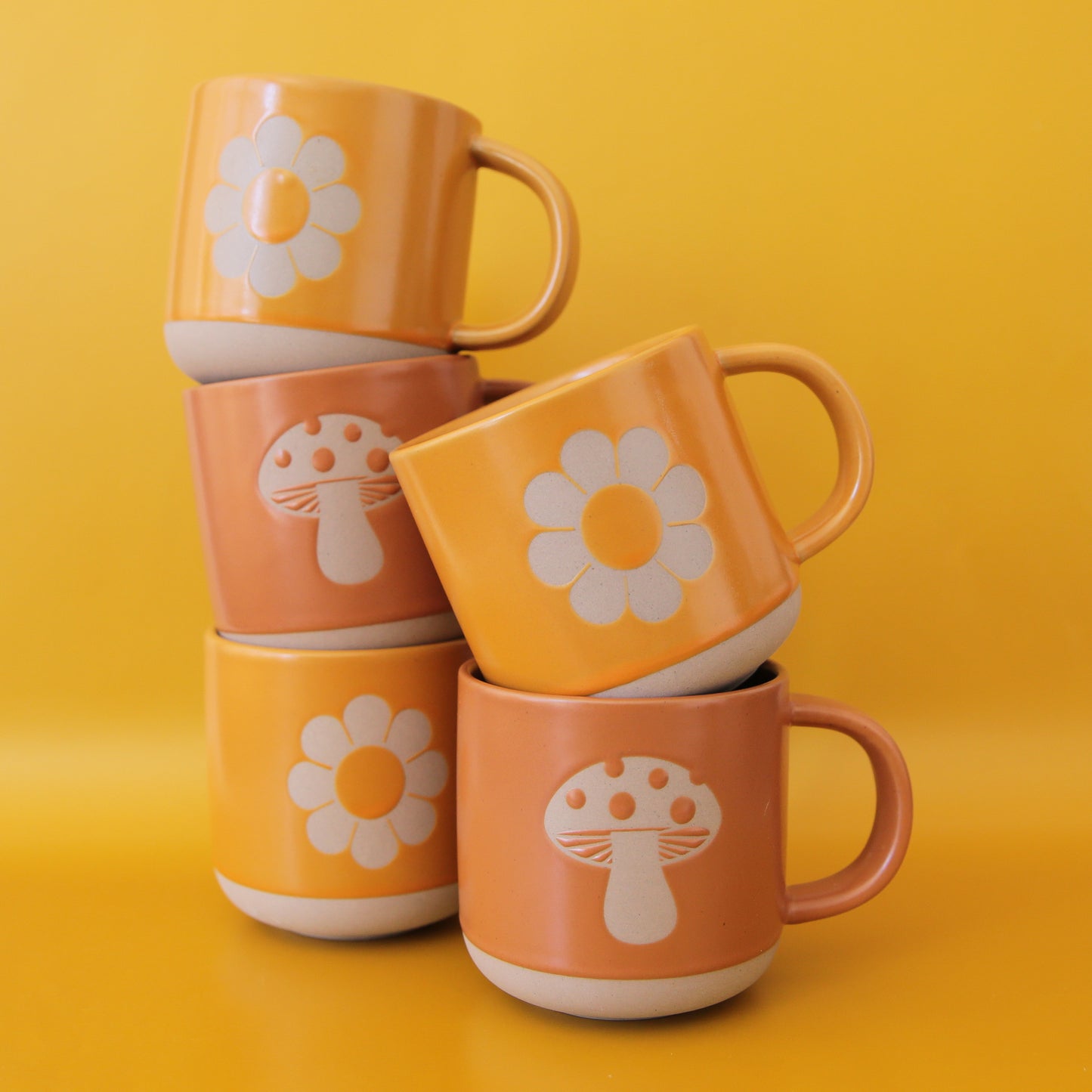 Our flower mug and mushroom mugs stacked on one another.