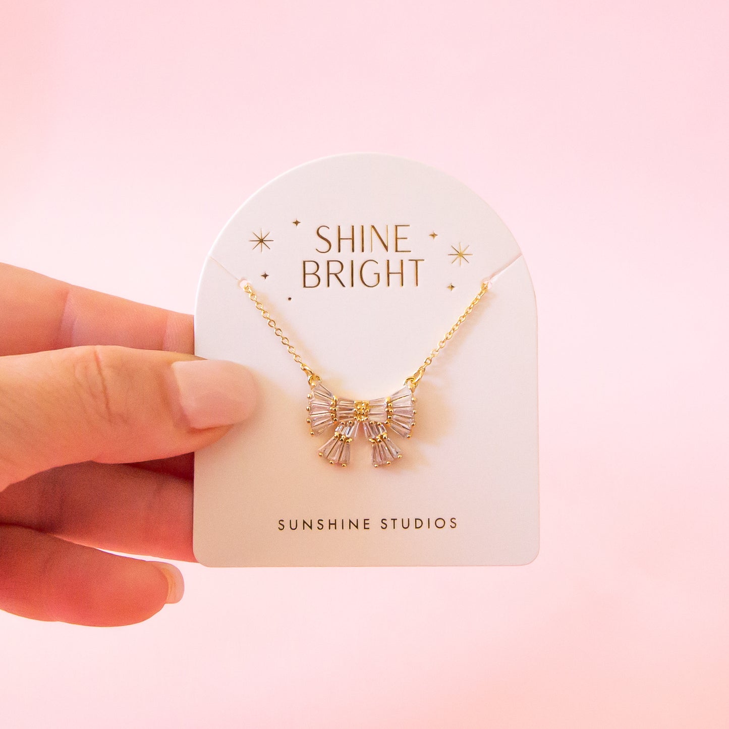 A bow shaped necklace with emerald shaped cz stones.
