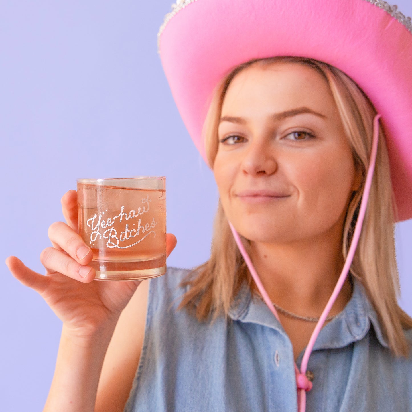 A short glass tumbler with white screenprinted text that reads, "Yee-haw Bitches".
