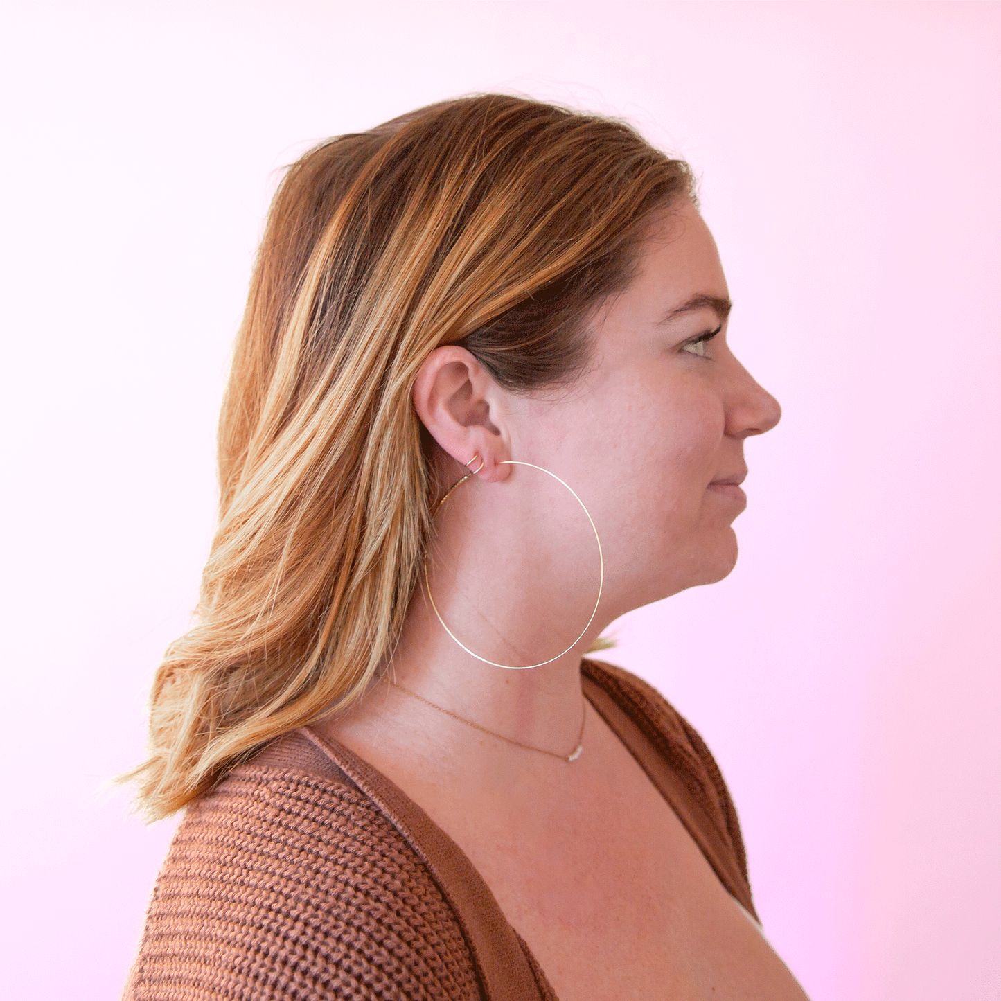 A model wearing the super dainty and large soho hoop earrings.