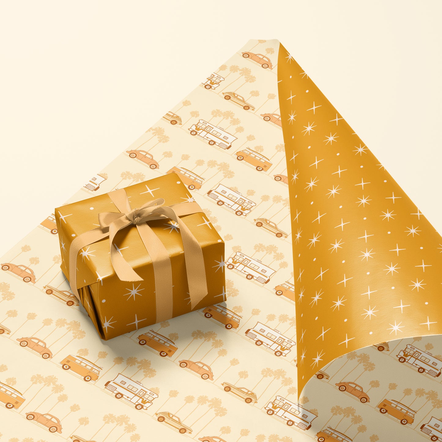 A single sheet of gift wrap featuring a mustard yellow background with a repeating white star design. On the flip side, you have the option of a cream background with groovy vehicles including vintage inspired RV's, and VW bugs and buses.