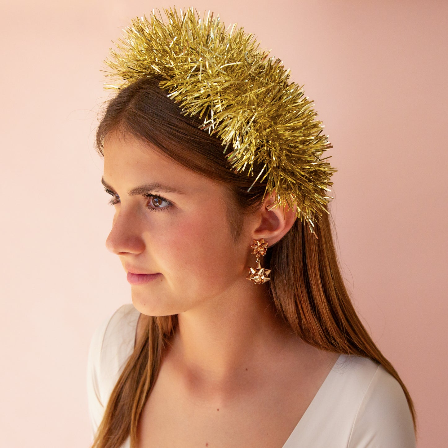 A gold tinsel headband sits on a young girls head.
