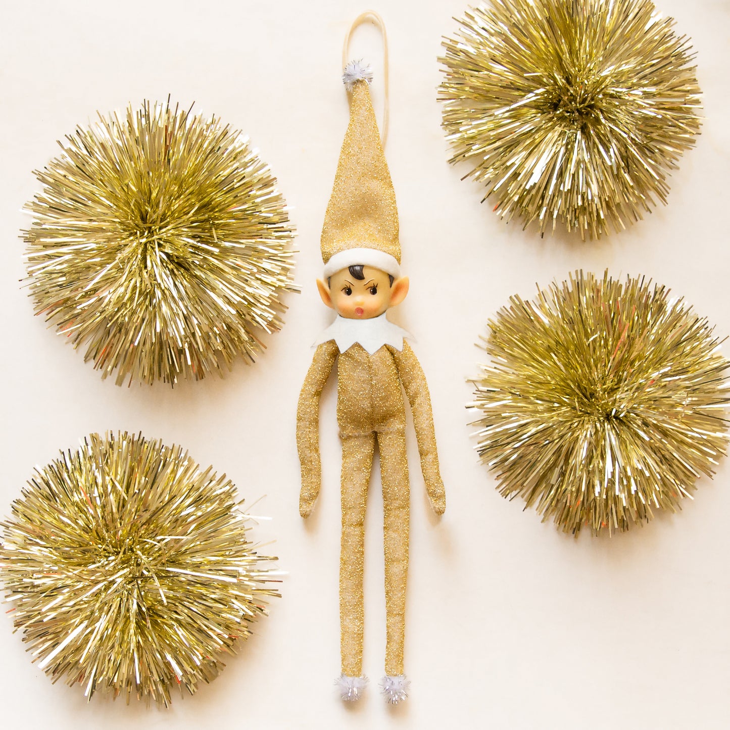 A gold sparkled elf shaped ornament.