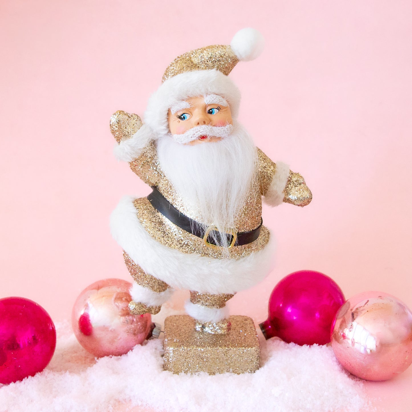 A gold glitter Santa figurine.