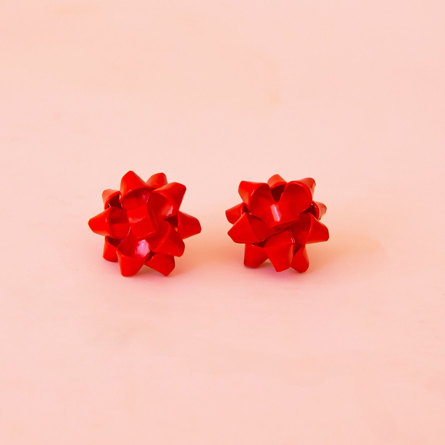 A red pair of bow shaped earrings.
