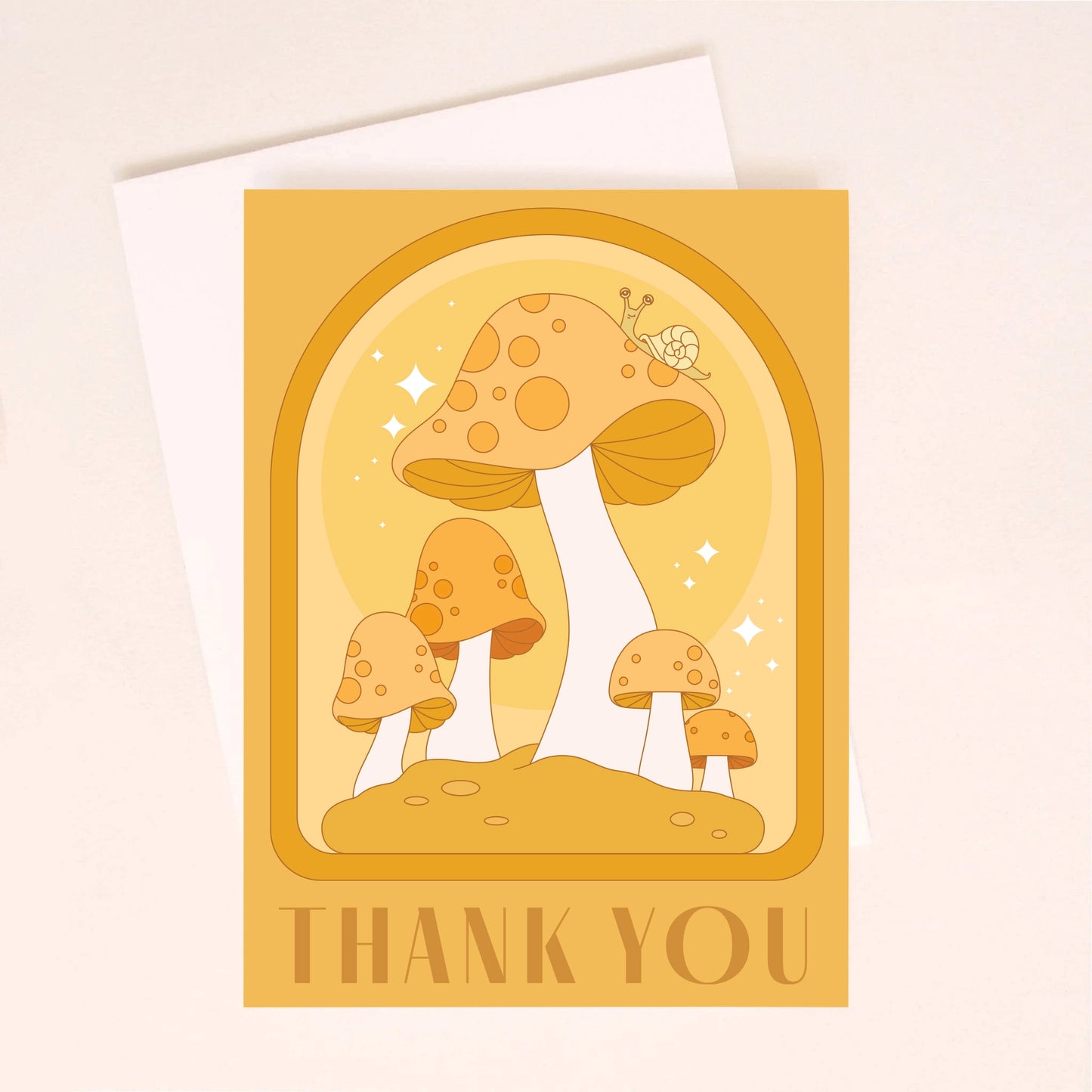On an ivory background is an orange greeting card with an arched design, mushroom illustrations with a little snail on top of the largest one and text along the bottom that reads, "Thank You".