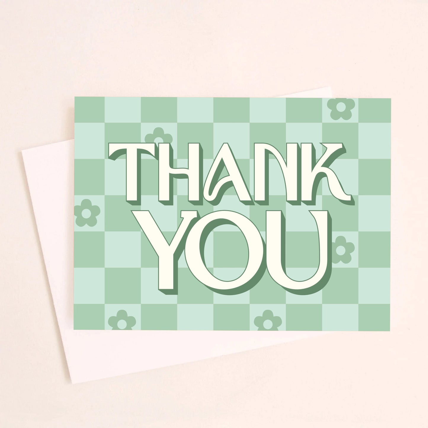 On a white background is a green checker print greeting card that reads, "Thank You" along with scattered daisies in some of the squares.