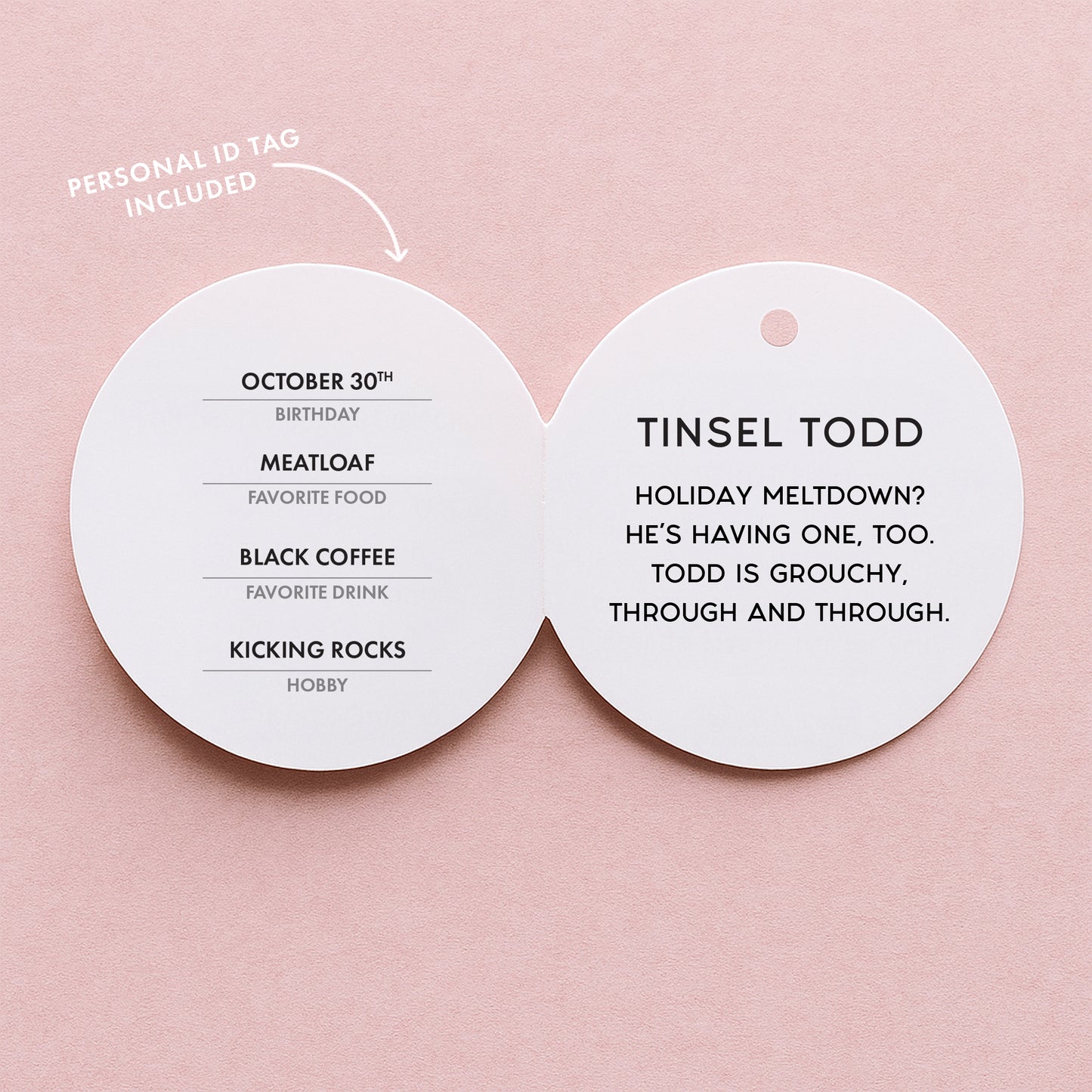 A photo of the tag attached to the elf that reads 'Birthday, Favorite Food, Favorite Drink, Hobby, Tinsel Todd Holiday Meltdown? He's having one, too. Todd is grouchy through and through'.
