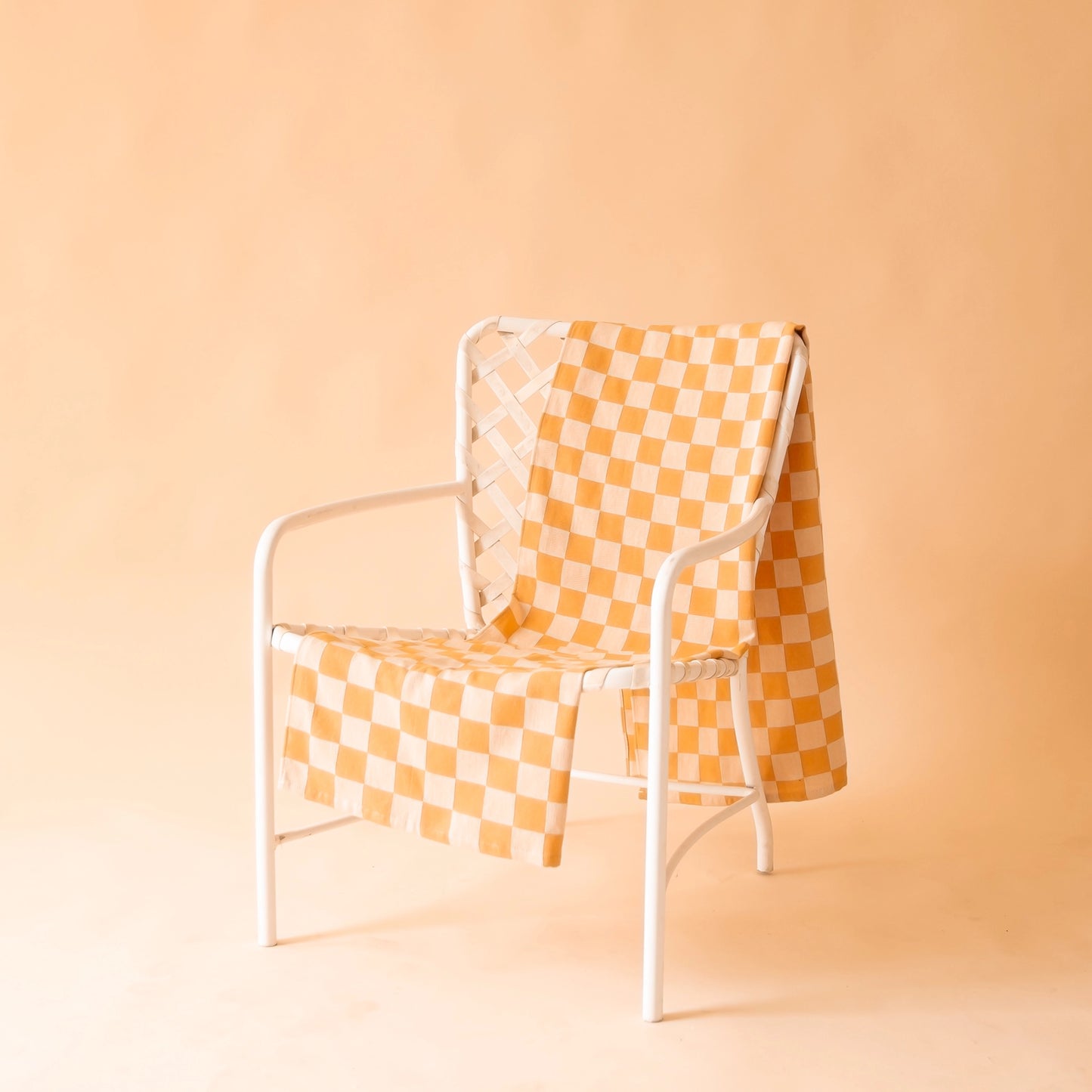 On a tan background is an orange and and light orange beach towel.