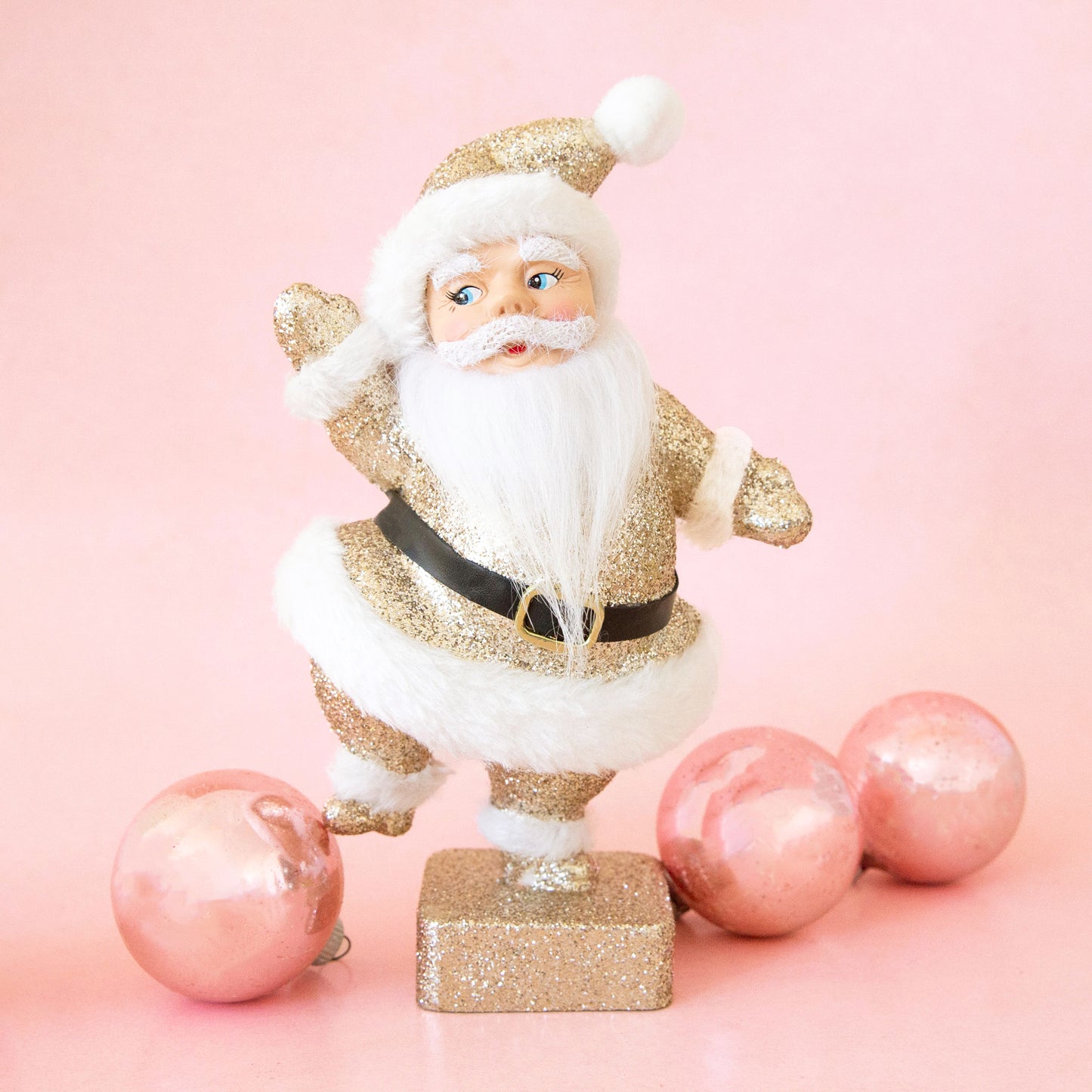 A gold glitter Santa figurine.