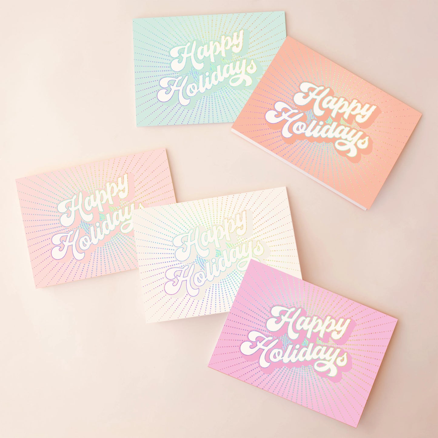 On an ivory background is a 5 pack of holiday greeting cards in shades of pink, ivory, blue, orange and hot pink.