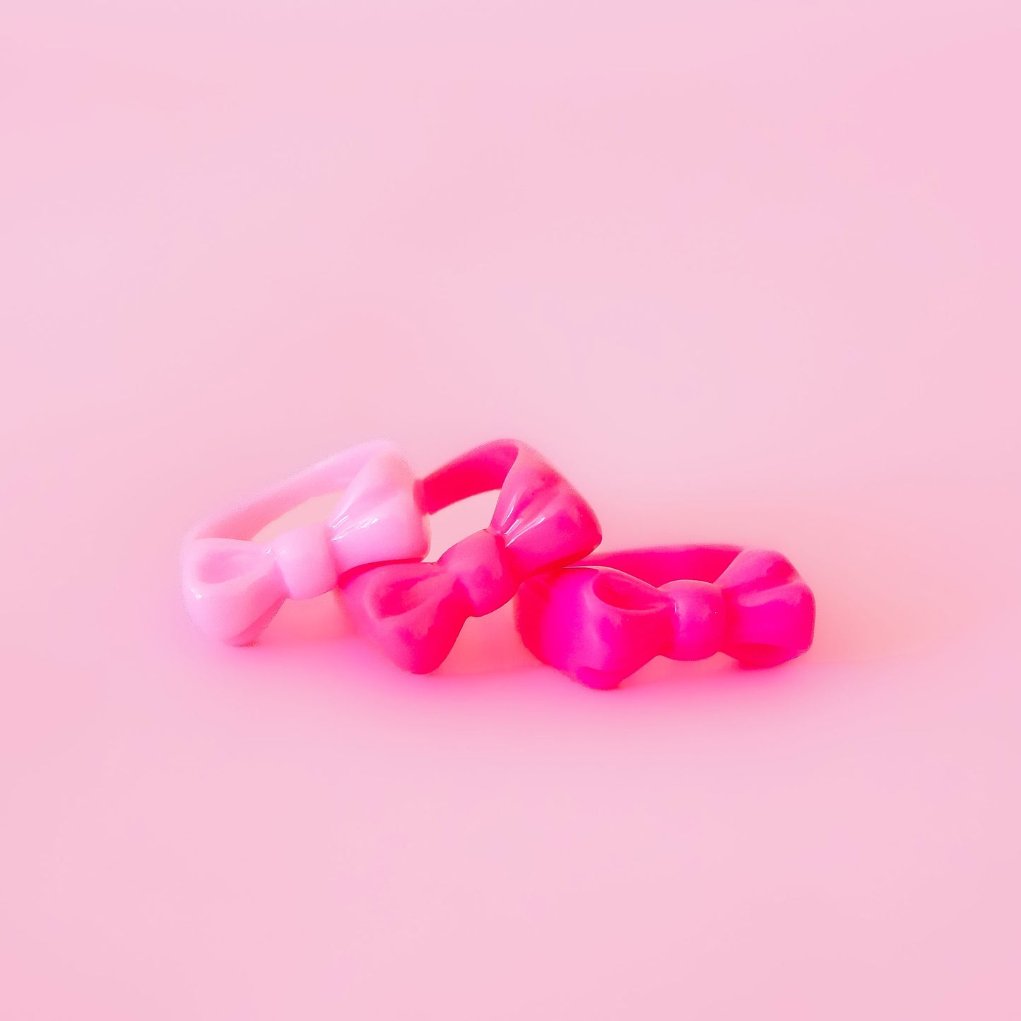A set of three pink bow shaped rings.