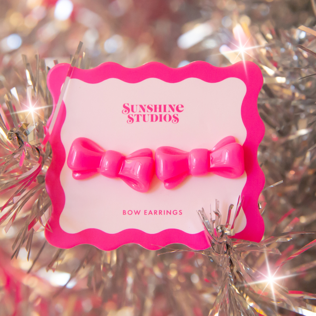 A pair of red bow shaped earrings.