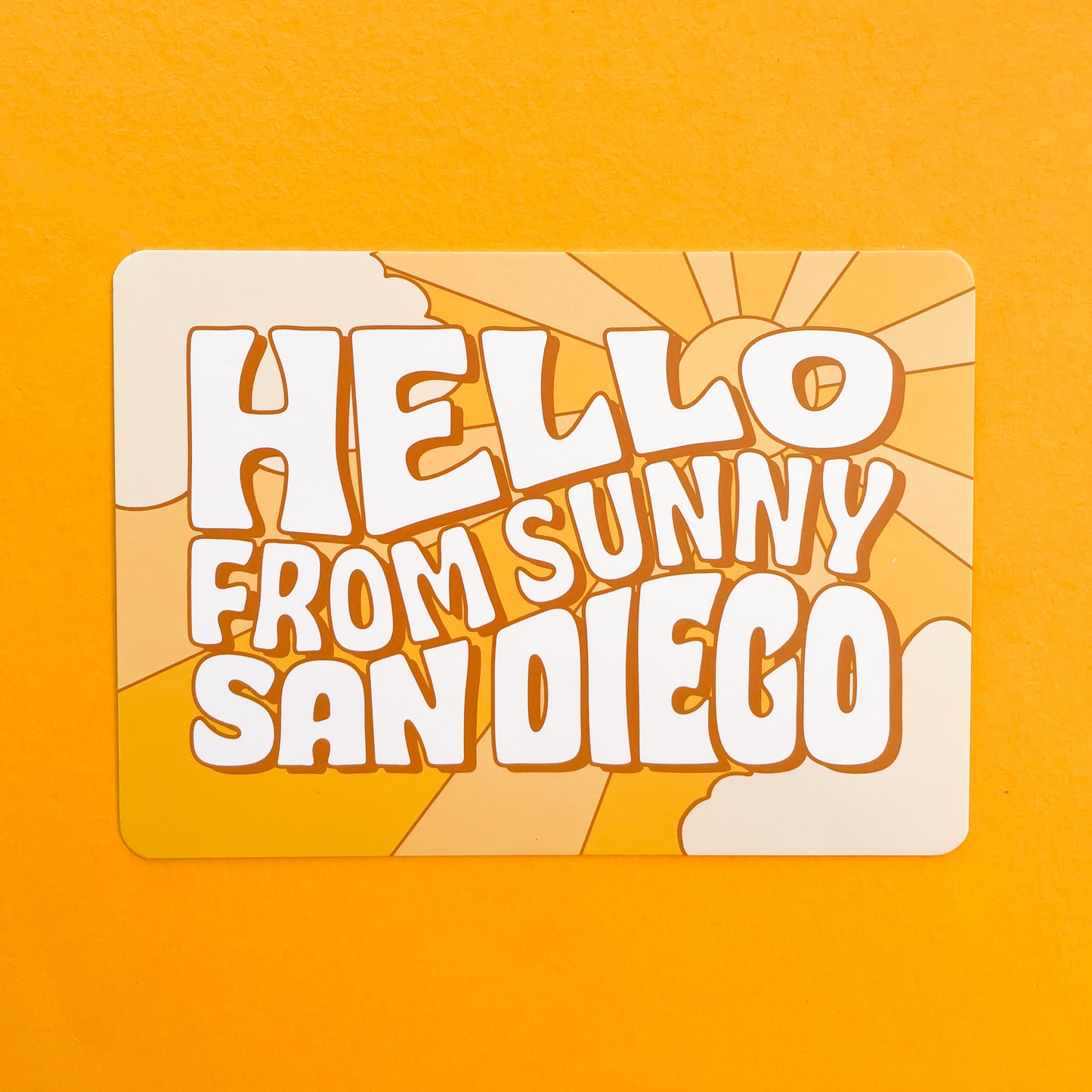 An orange postcard with 70's style text that reads, "Hello From Sunny California".