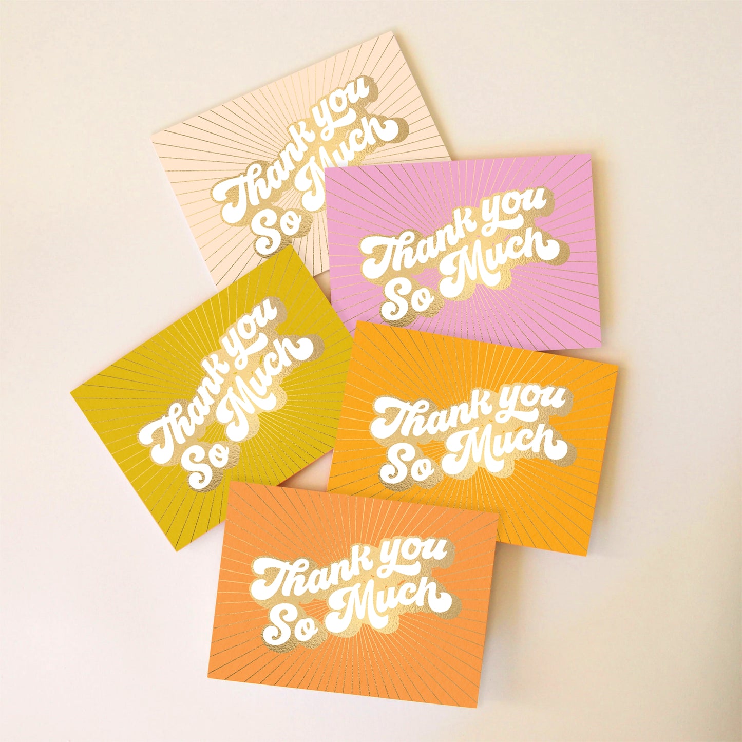 On an ivory background is a pack of 5 thank you cards in a variety of colors that all read, "Thank You So Much" in white letters and gold foiled outlined.