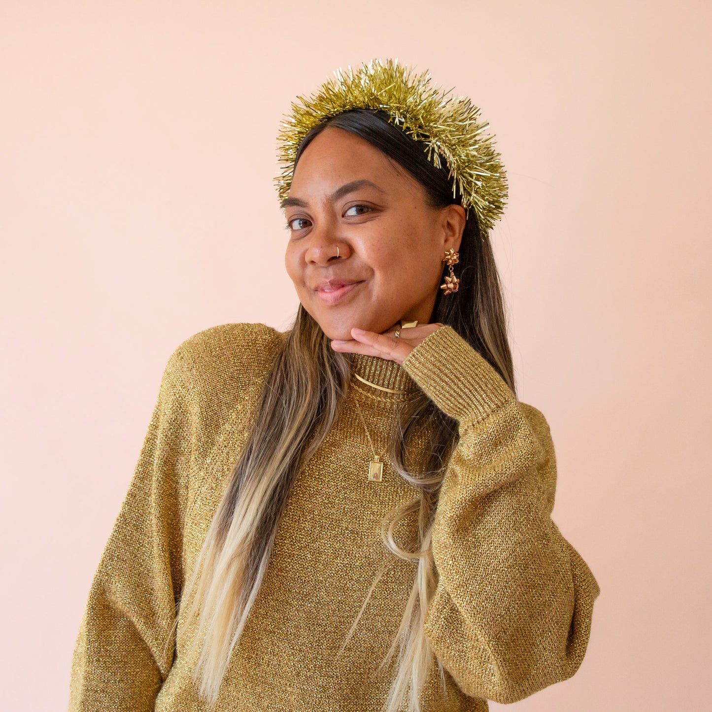 A gold tinsel headband sits on a woman's head.