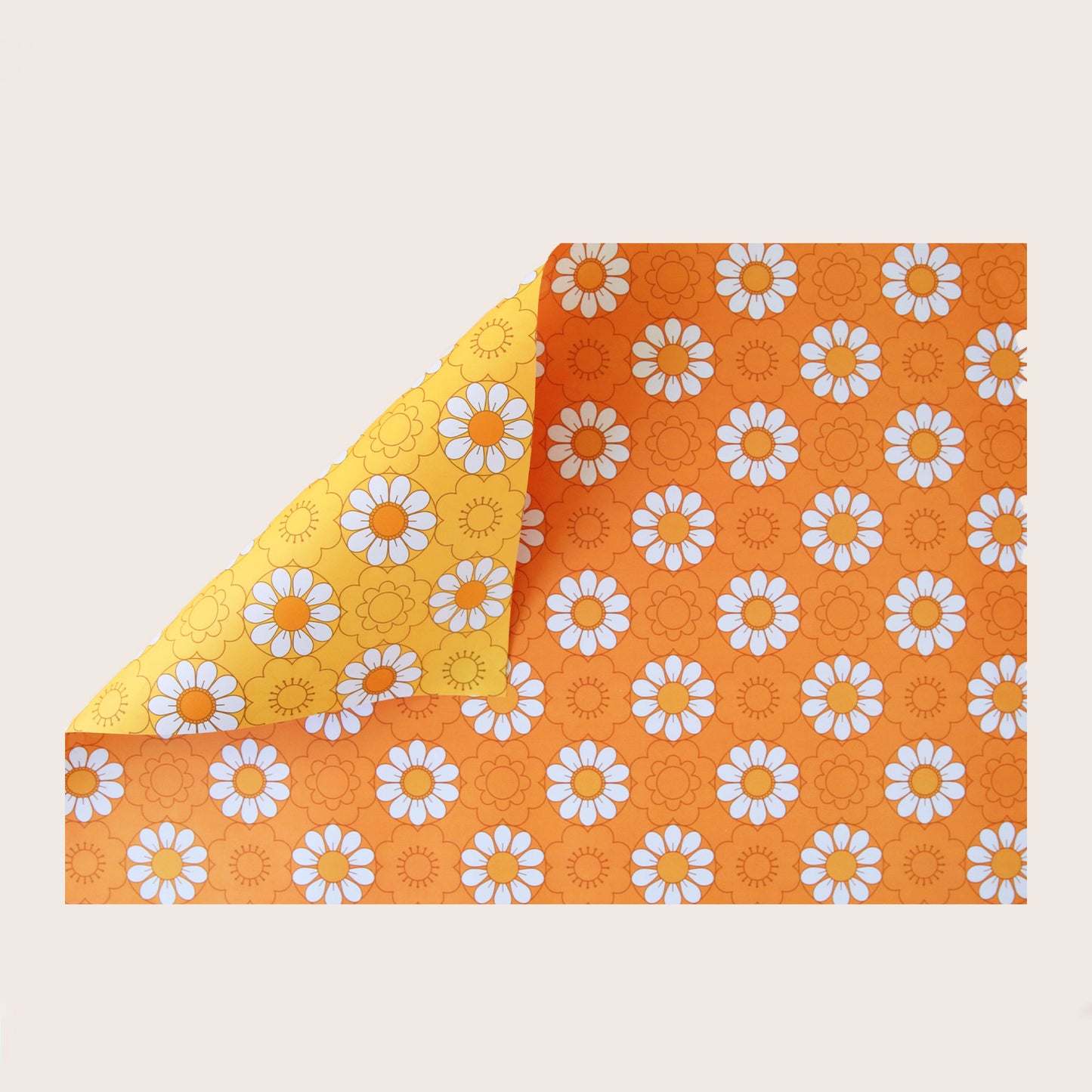 A single sheet of gift wrap with reversible sides. One side features a daisy print on a mustard yellow background while the other side features the same print on an orange background.