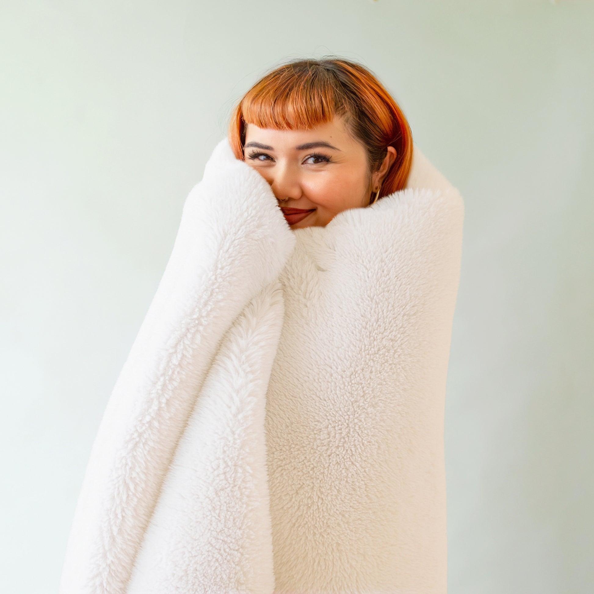 An ivory white faux fur blanket. 