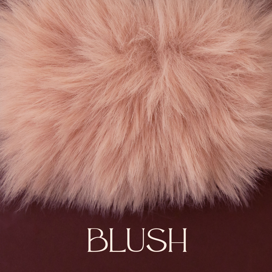 An ivory blush faux fur blanket. 