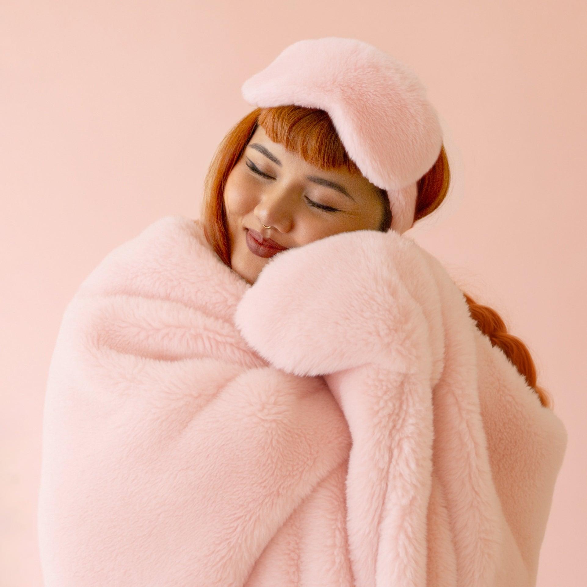 A light pink faux fur blanket.