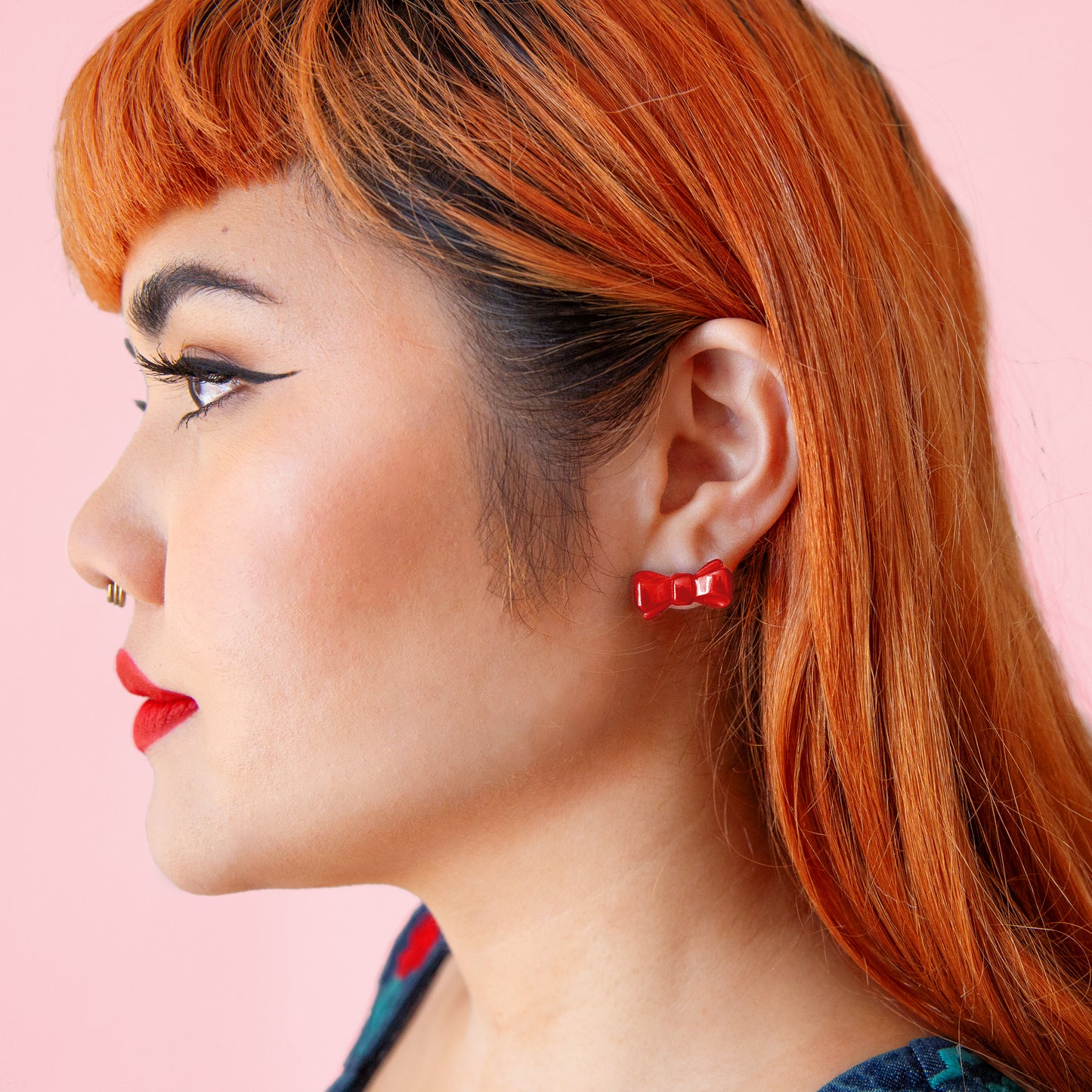 girl wearing red bow earrings