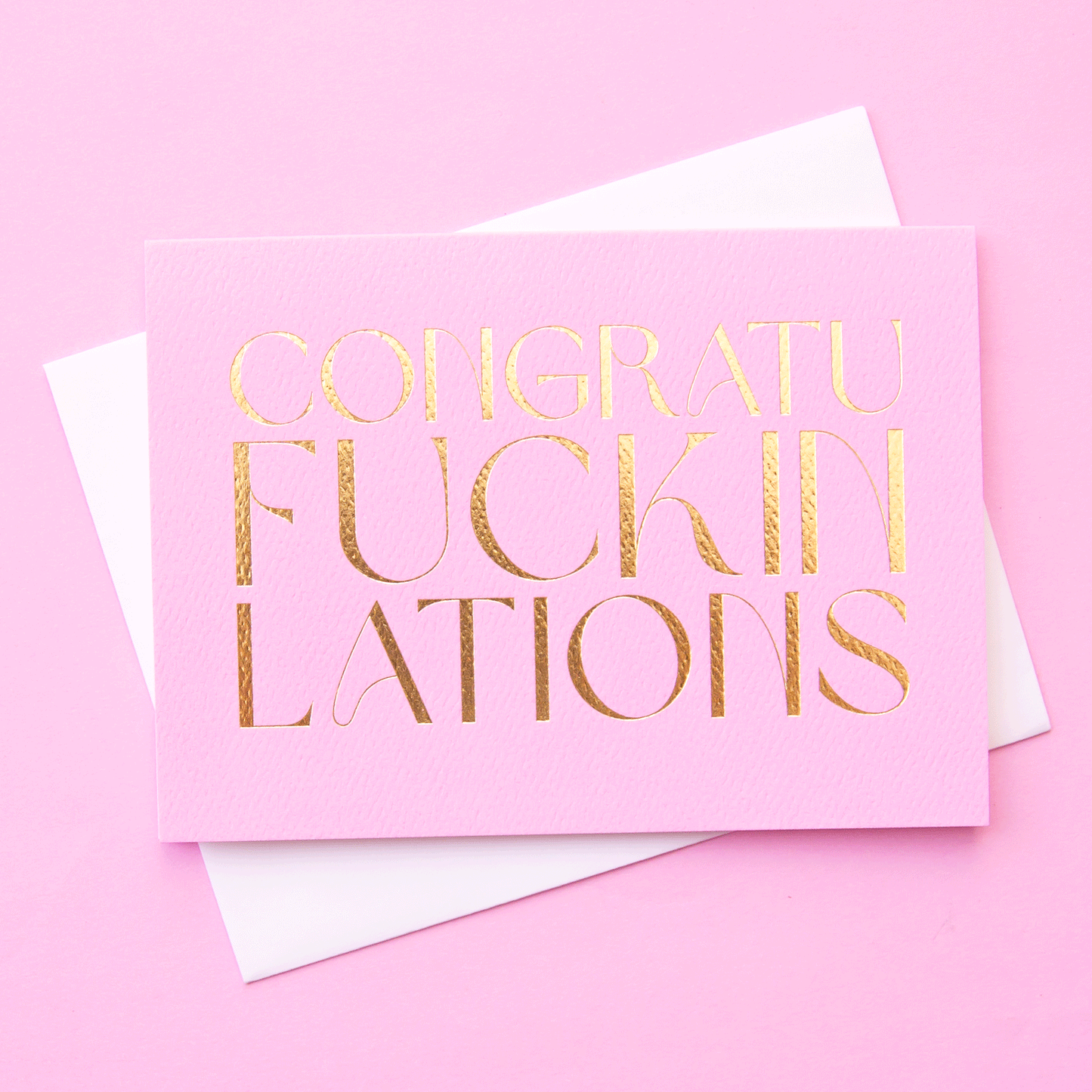 On the same colored background is a purple pink greeting card with gold foil text that reads, "Congraufuckinlations".