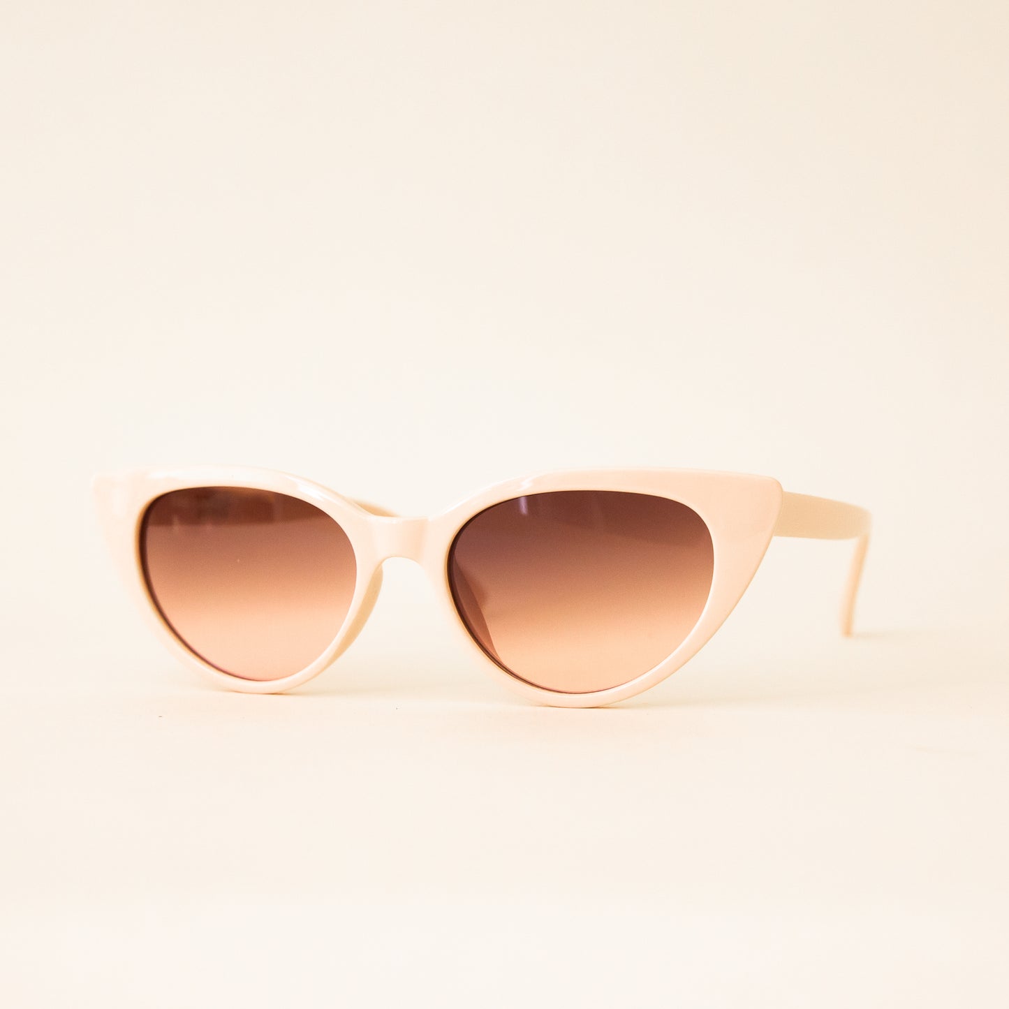 A pair of ivory cat-eye shaped sunglasses.