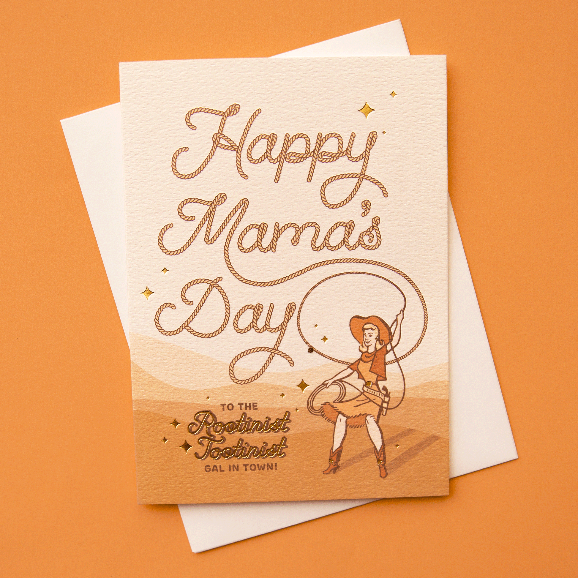 On an orange background is a orange and tan card with rope styled text that reads, "Happy Mama's Day To The Rootinist Tootinist Gal In Town!" along with a women with a cowgirl hat and lasso.