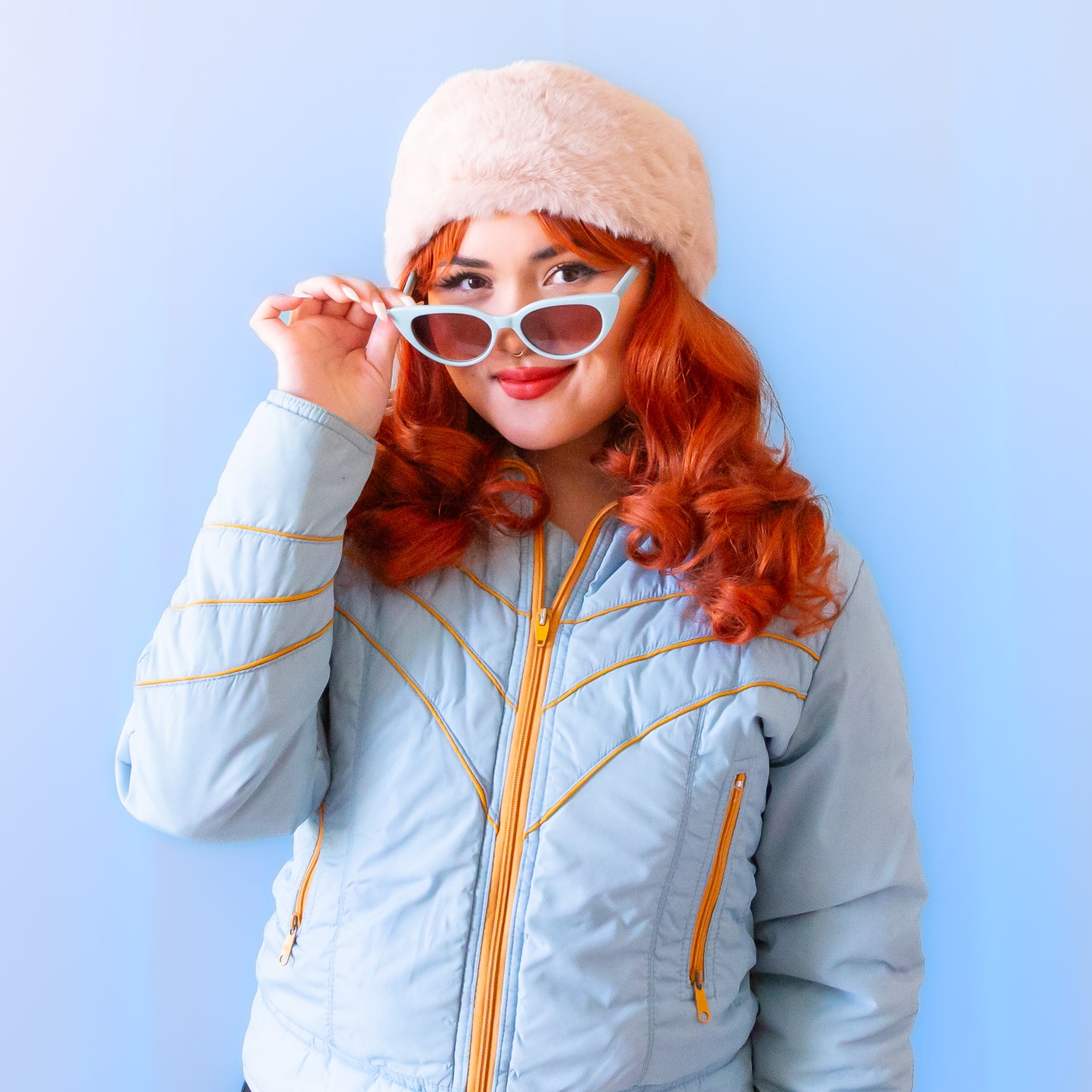 A light blue pair of cat-eye shaped sunglasses. 