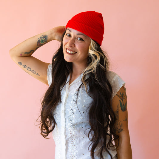 A bright red ribbed beanie. 