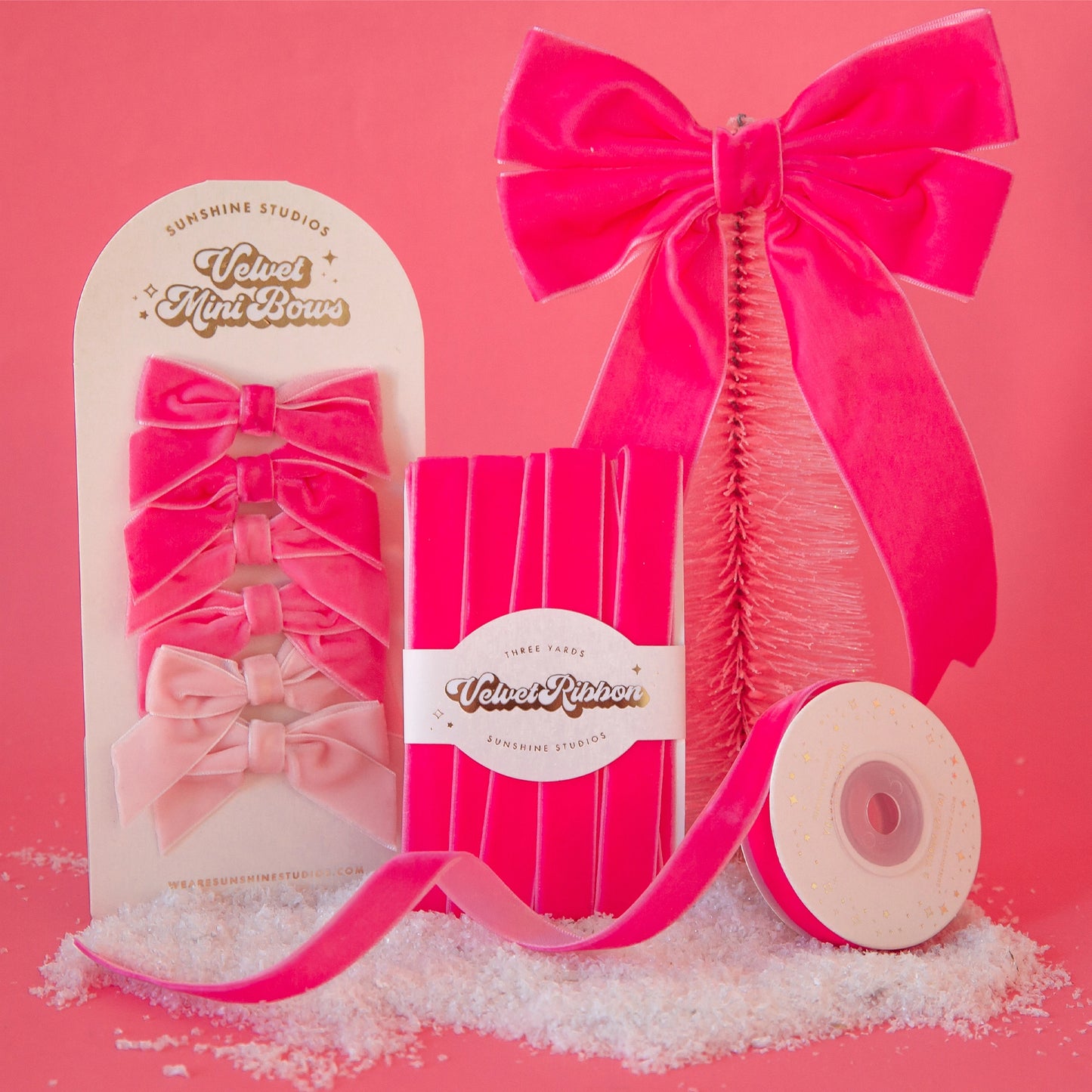 On a pink background is the entire collection of pink velvet bows and ribbons.