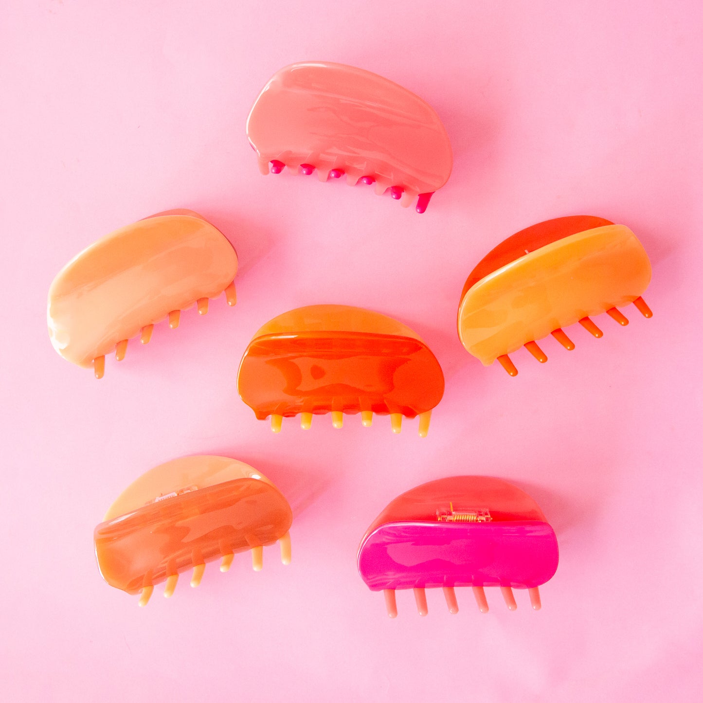 All three of our two-toned claw clips side by side in tones of pink and orange. 