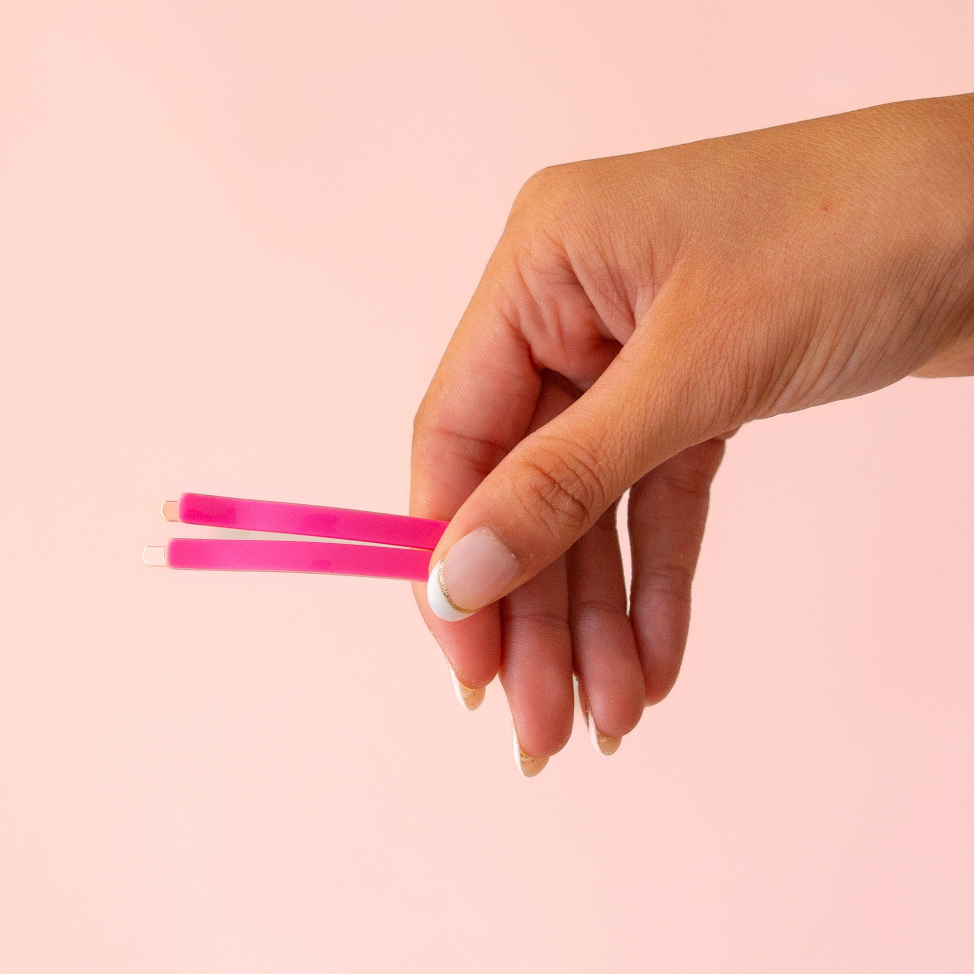 A set of 6 straight bobby pin clips in pink and orange.