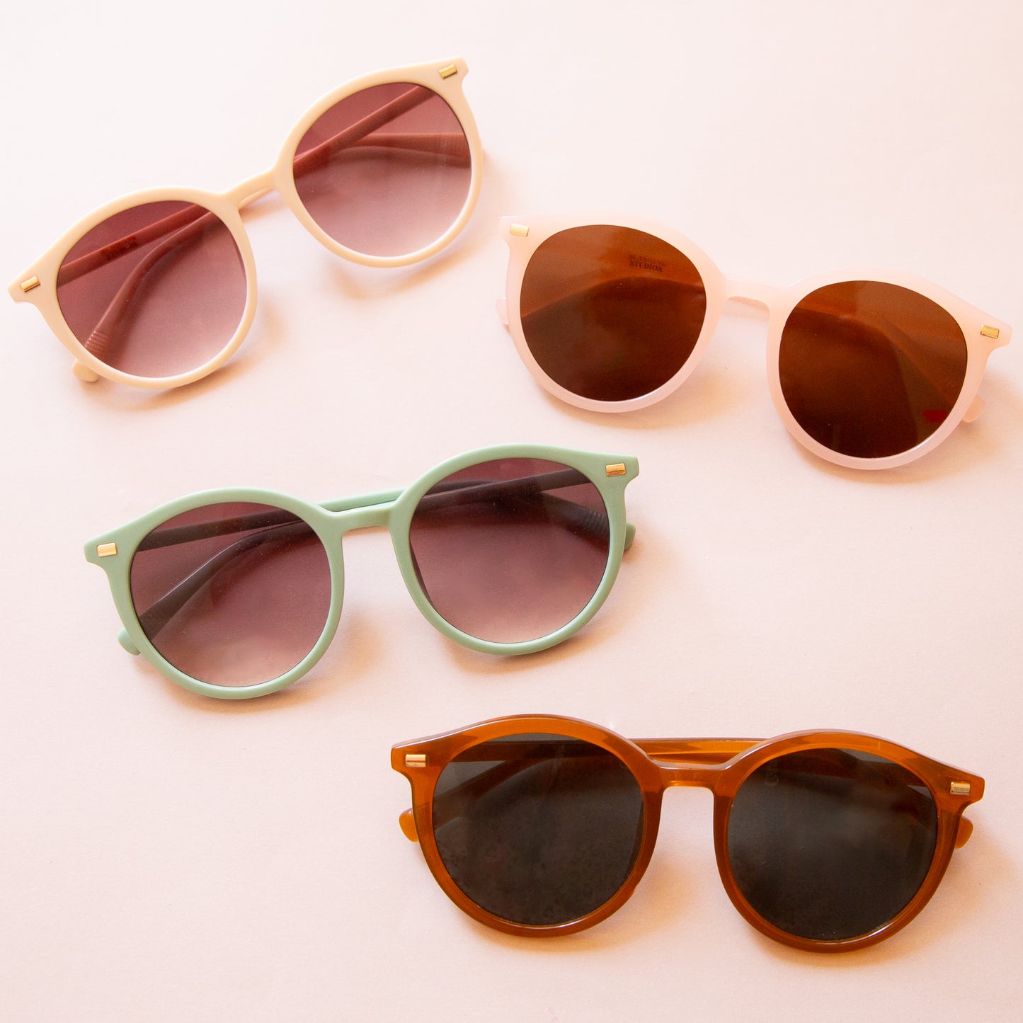 On a peach background is the three Sam sunglasses in the four color ways.