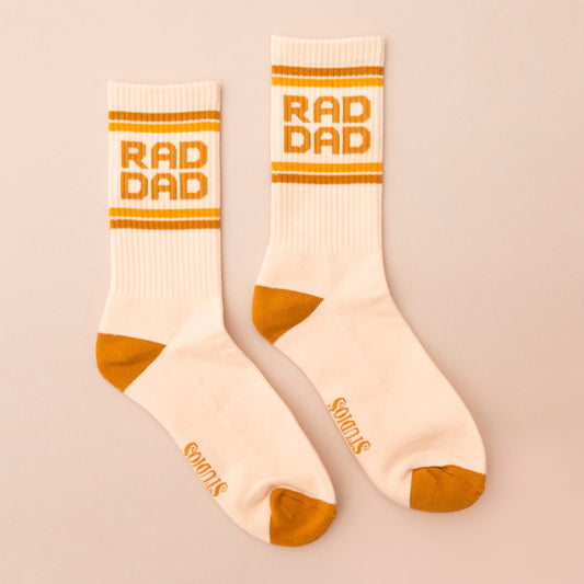 cream colored socks with gold accents and "rad dad" along the top