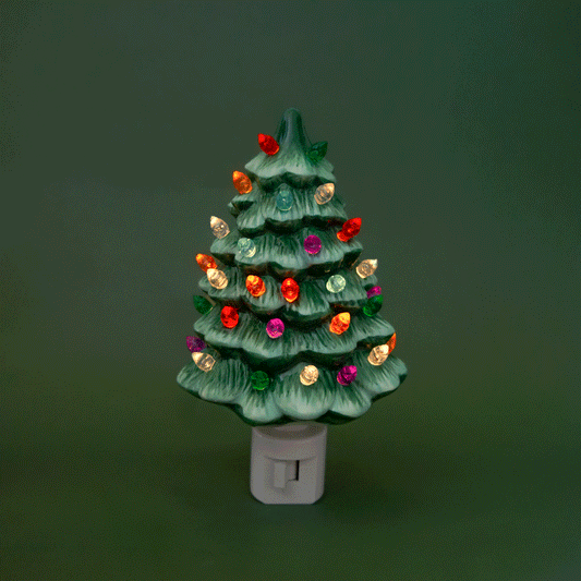 A ceramic Christmas Tree shaped night light sits in middle of the page with bright colorful lights.  It has a white plug at the bottom.  The tree is a green color.