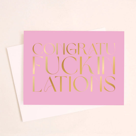 On an ivory background is a purple pink greeting card with gold foil text that reads, "Congraufuckinlations".