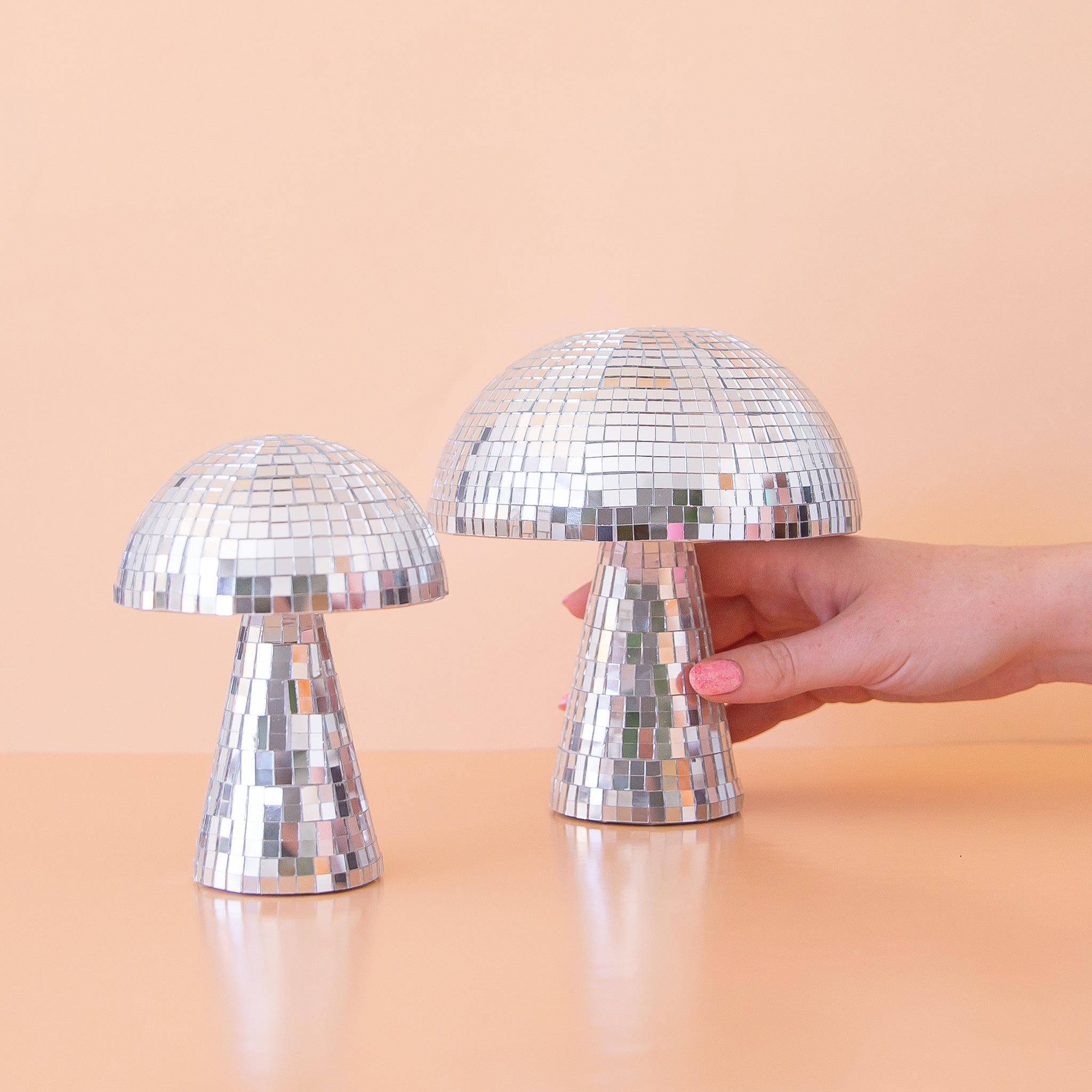 two disco mushrooms on a peach ground