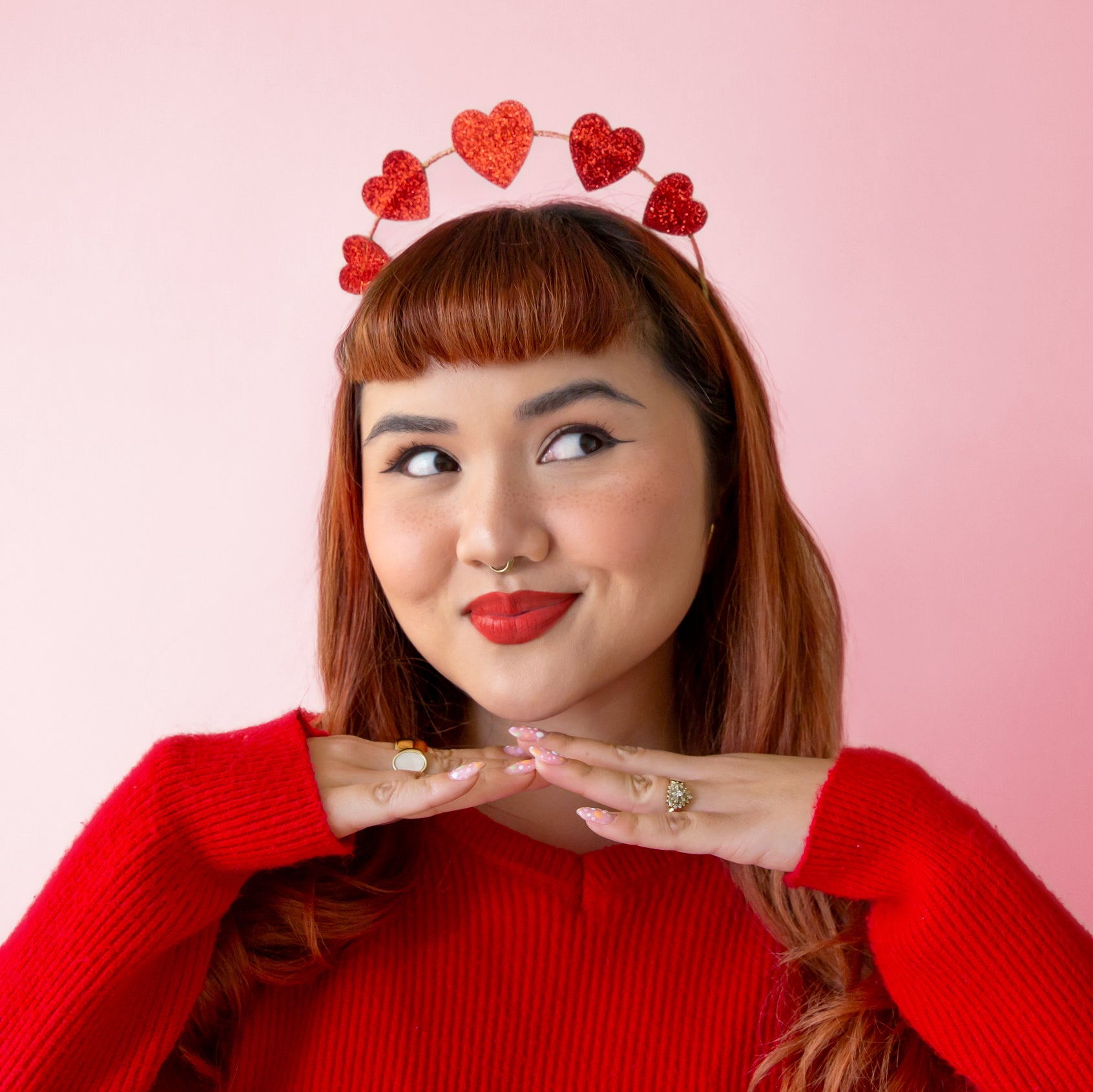A headband hair accessory with red glitter hearts along the top. 
