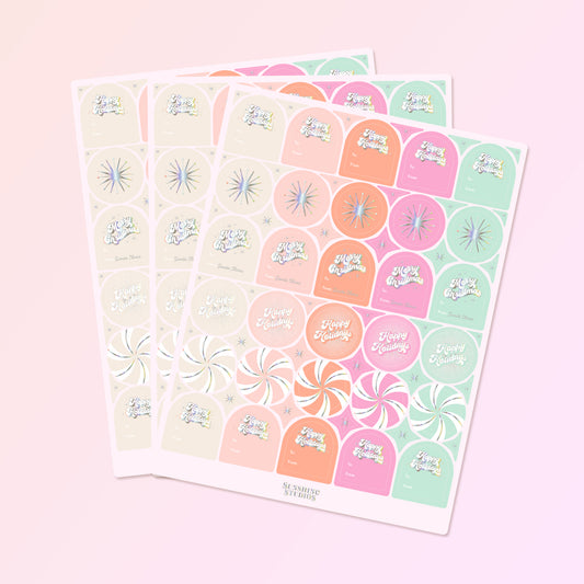 On a pink background is three sheets of gift labels with shades of pink, orange, mint and ivory along with holographic text and designs.