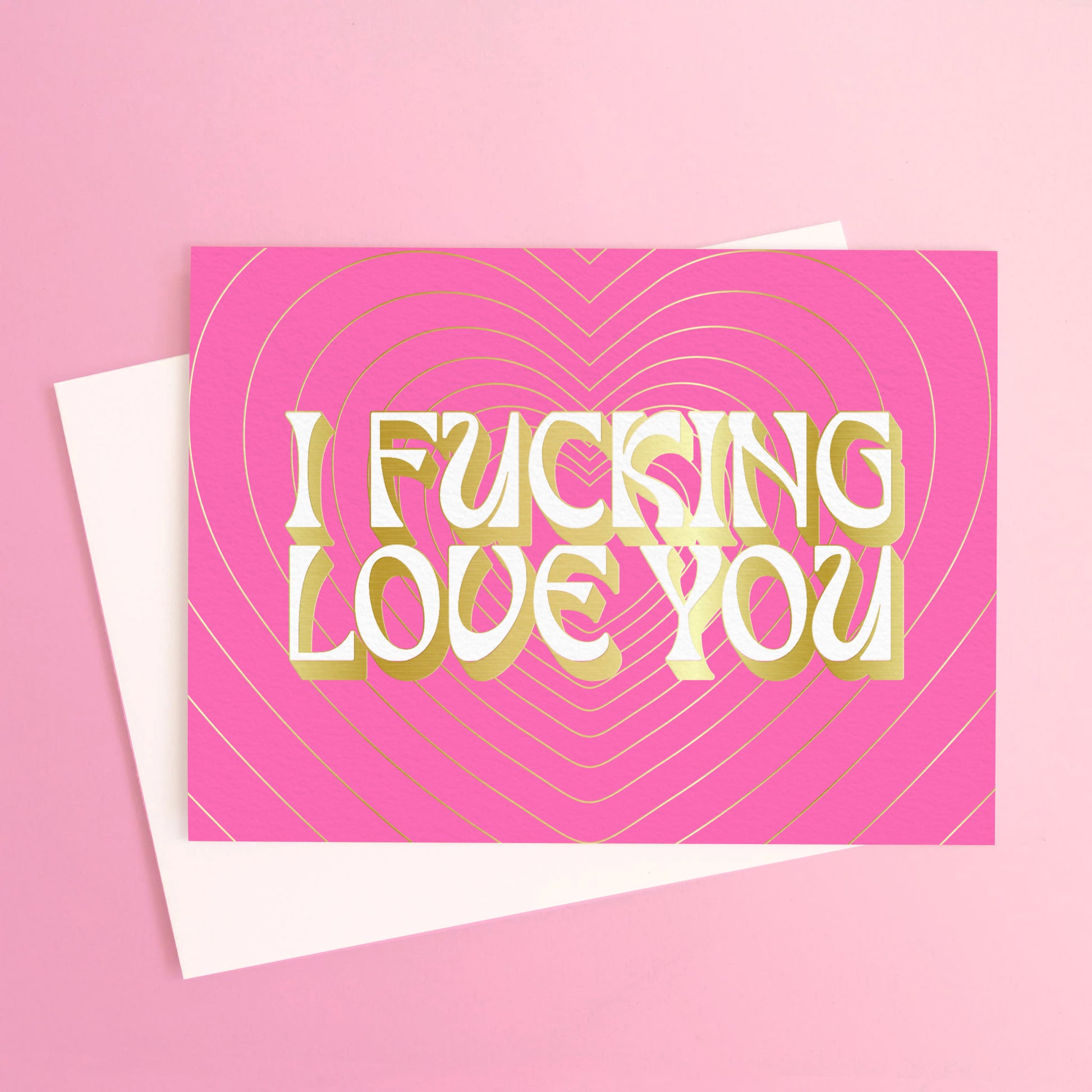 Bright pink greeting card, with a radiating gold foil heart design. The words "I Fucking Love You" are written in bold lettering. 