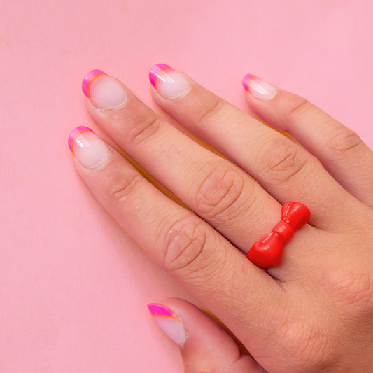 hand wearing a red bow ring