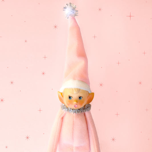 A light pink baby elf ornament. 