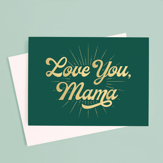 On a blue background is a dark green card with gold foil text that reads, "Love You, Mama".