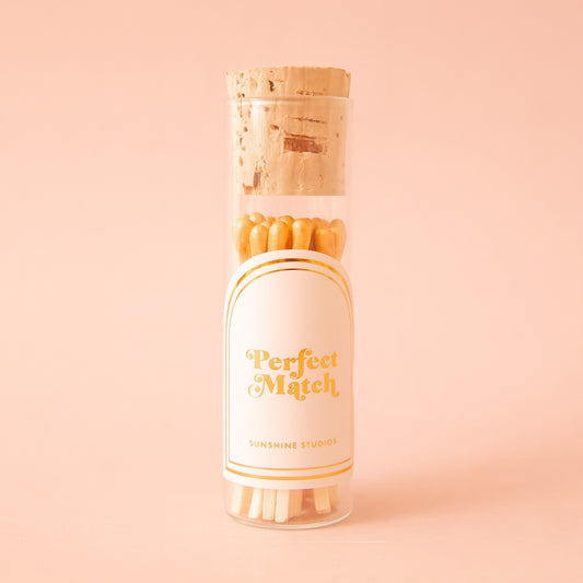 A small glass vial of wooden matches with a label that reads, 'Perfect Match'. 