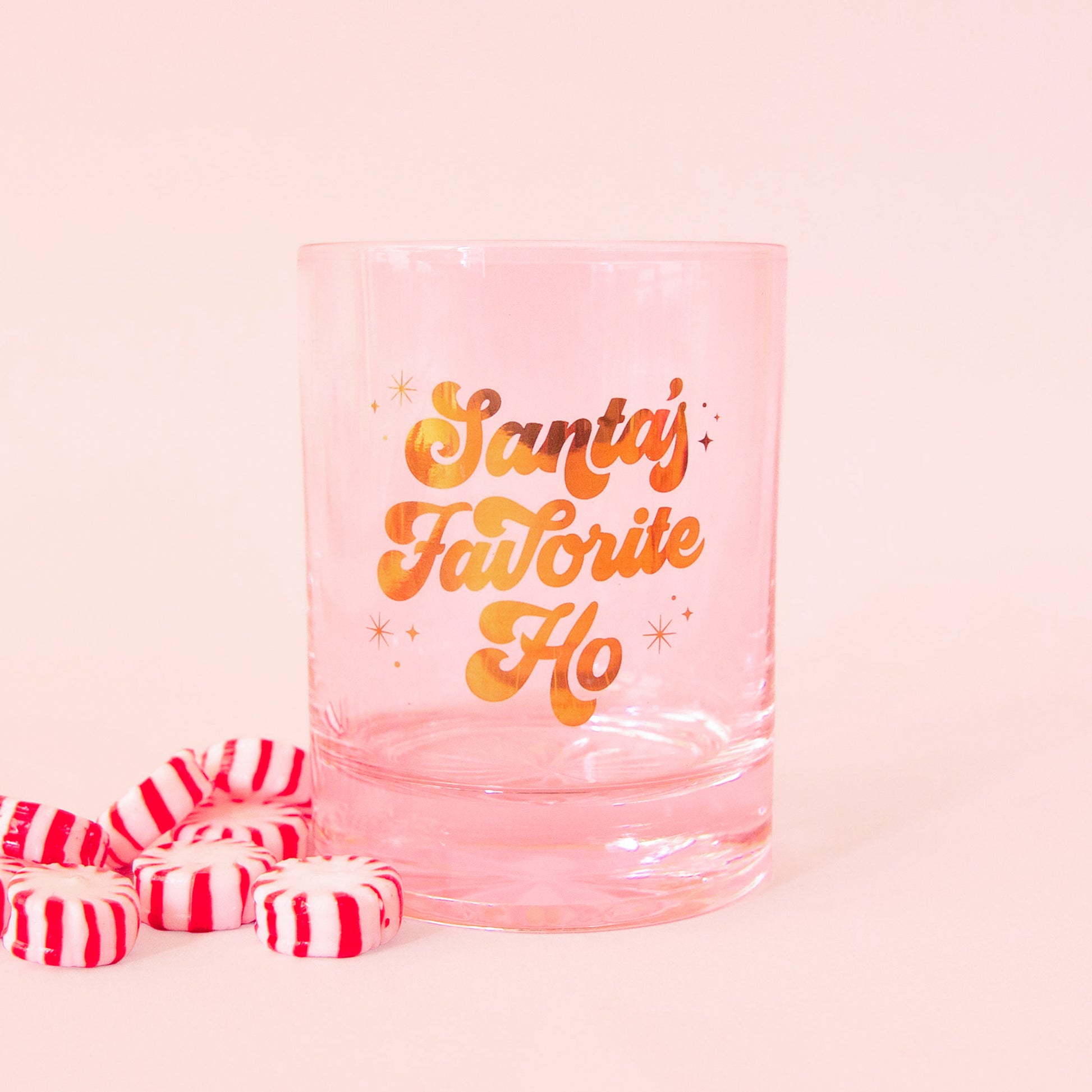 pink glass tumbler with gold script font that says "santa's favorite ho"