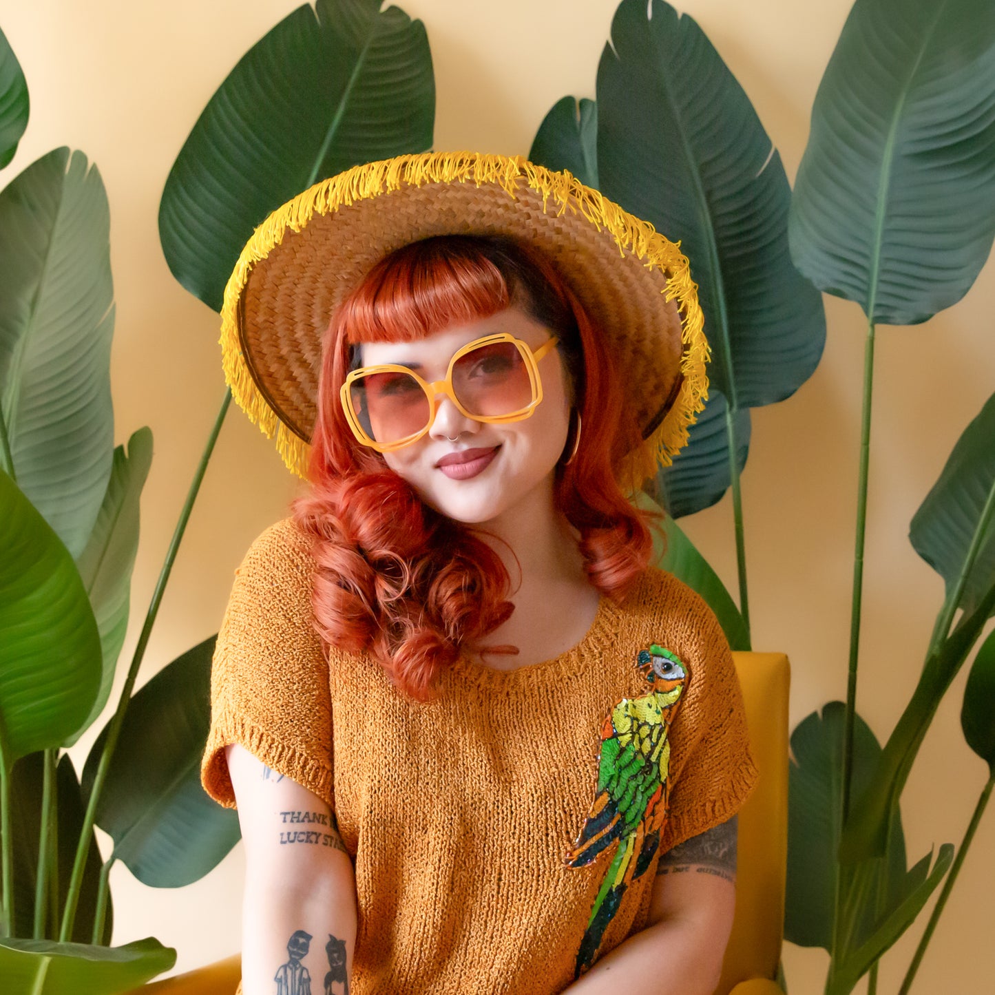 A pair of round sunglasses with yellow frames and a brown gradient lenses. 