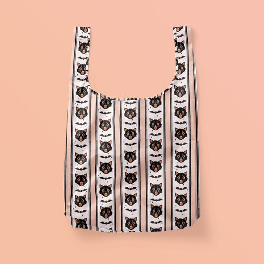 Reusable tote bag with black cats and bats in a vertical stripe pattern. 
