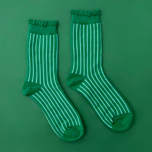 A pair of emerald green crew socks with a lighter green stripe and a ruffle edge at the top. 